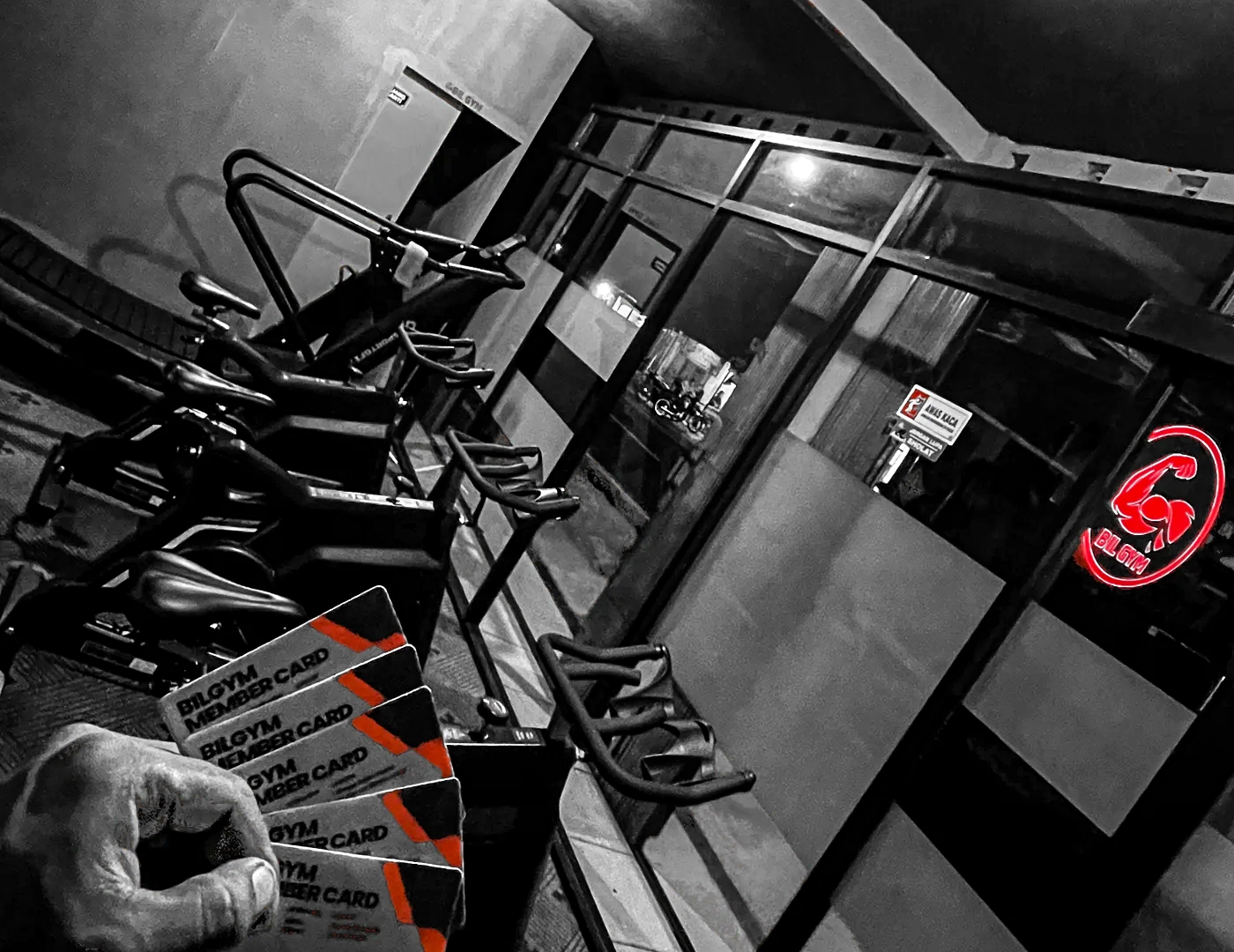Inside Bil Gym Purworejo — spin bikes and the red BIL GYM neon sign